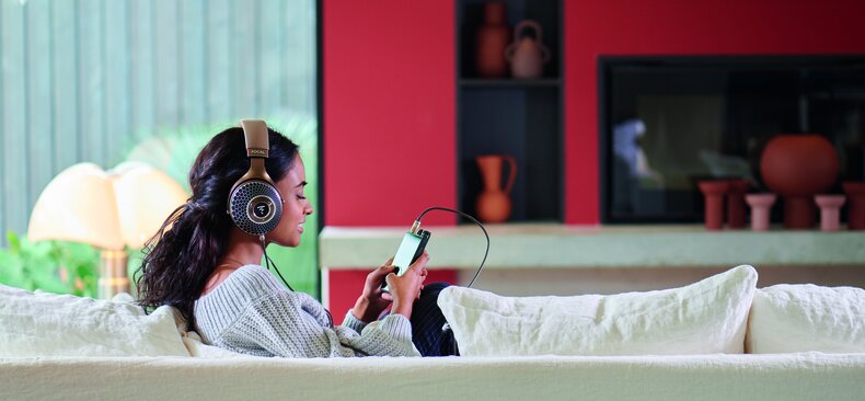individual wearing the focal clear MG headphones and typing on a DAP
