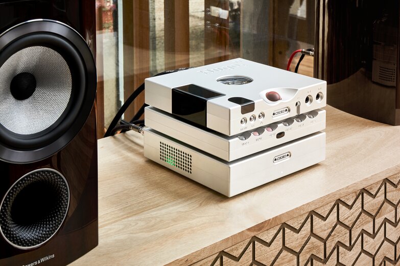 Hugo M Scaler stack next to bookshelf speaker on wooden cabinets