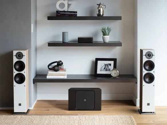 powernode on the floor in between the standing speakers in front of shelves