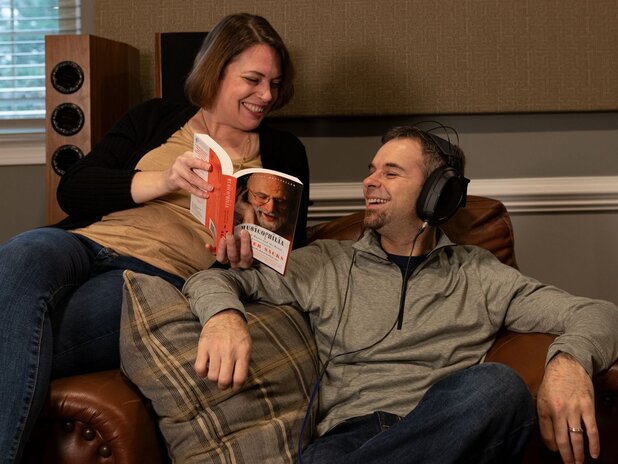 woman and man sitting on chair with headphones on 