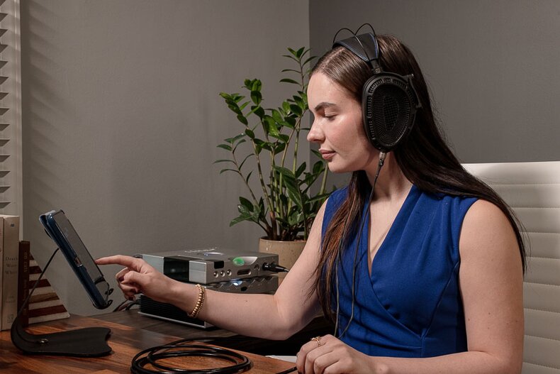Woman sitting at a desk wearing Dan Clark Audio Stealth Headphones
