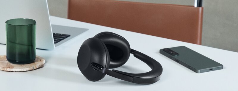 Sony 1000X THE COLLEXION Headphones on a desk next to a laptop and smartphone