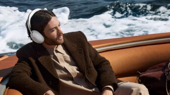 man leaning on a boat sitting with 1000x on
