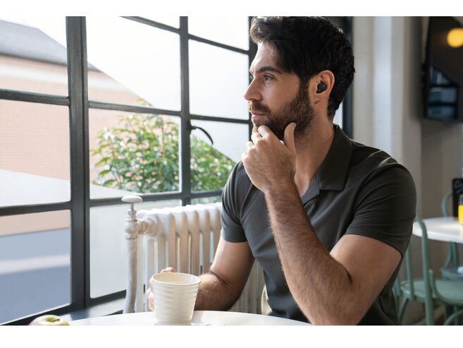 Man drinking coffee with headphones