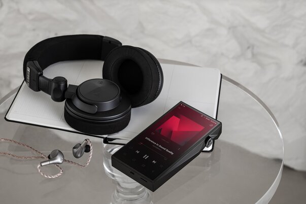 Astell&Kern SP4000 Digital Audio Player with wireless headphones and IEMs next to it 