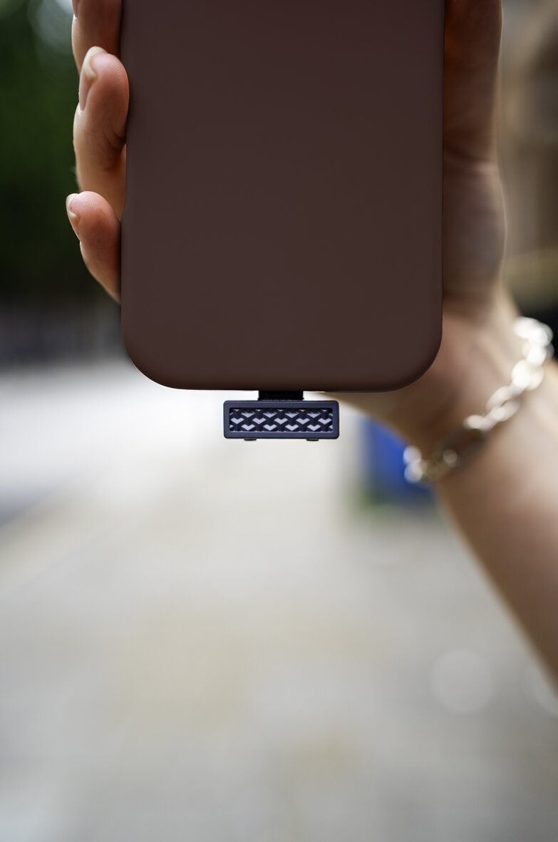 hand holding phone with transmitter plugged into usb