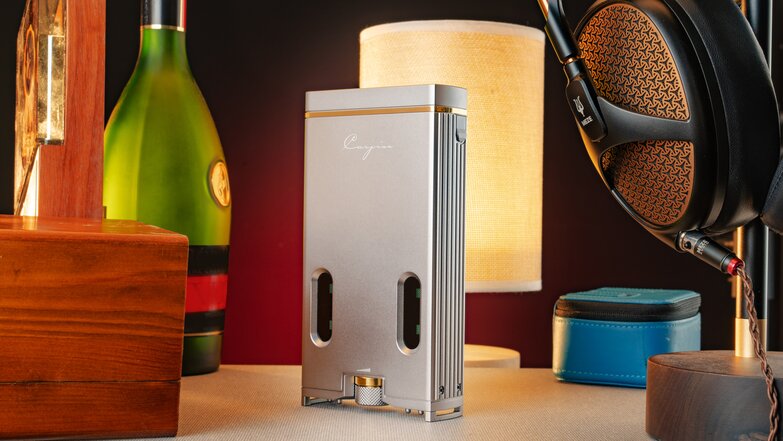 standing c9ii on desk with headphones, wooden box, glass bottle and items