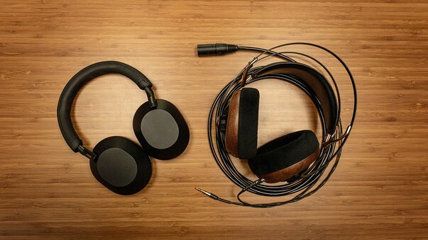 sony WH-1000XM5 wireless headphones and Meze Audio 99 classics headphones next to each other on table