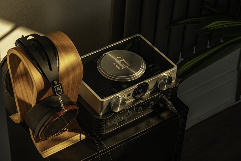 iFi Audio iCan Phantom with a pair of headphones placed next to it 