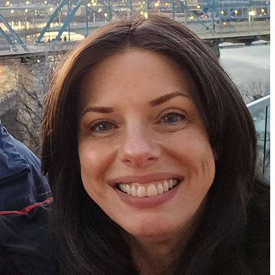 Original image of a woman seated in a car, smiling naturally—used as a before photo for Somny’s AI business portrait transformation.