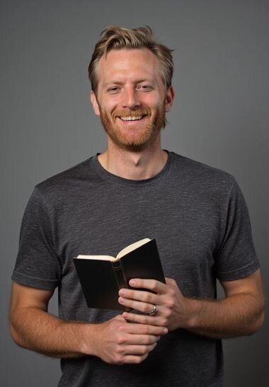 AI-generated image of a church staff member in front of a gray wall, smiling and holding a Bible.