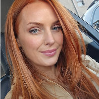 Original reference image of a red-haired woman in natural light, used to generate AI travel scenes.