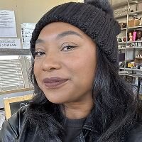 Natural close-up of a woman wearing a black knit hat indoors, used as a before photo for Somny’s AI character creation process.