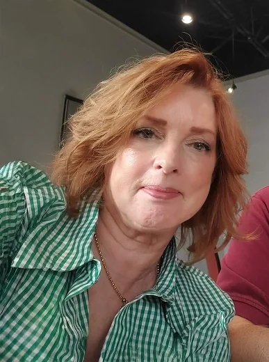 Simple phone selfie of a woman with a neutral background