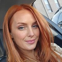 Casual photo of a red-haired woman taken in natural light, used as the original image for AI historical portrait generation.