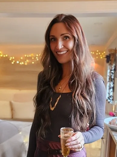 Phone selfie of a person in casual clothes with minimal background detail