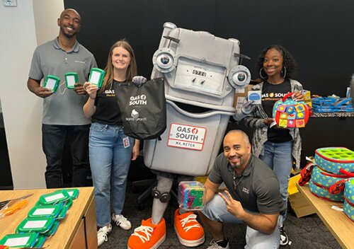 Mr. Meter donating toys with Gas South employees