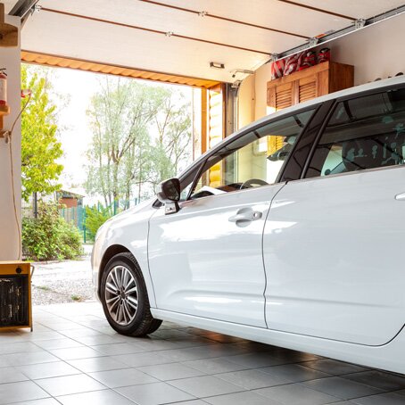 side view of white van in the garage with the door open to the yard