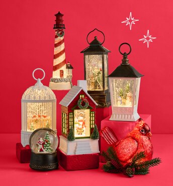 Glitter lanterns and snowglobes lit up in front of a red background