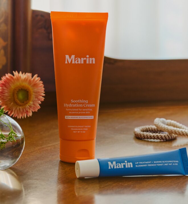 Marin Soothing Hydration Cream and blue lip treatment displayed on a wooden table.