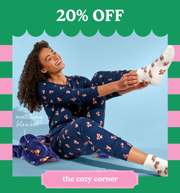 Image of a girl wearing cozy navy blue teddy bear pajamas with matching socks and blanket