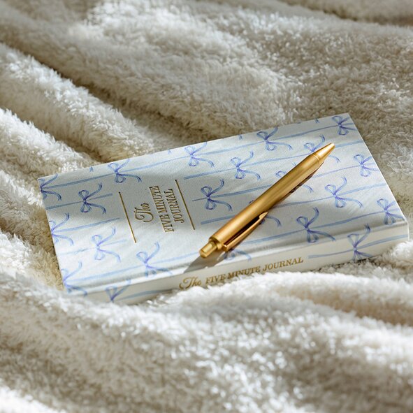 Image of a journal and a pen on a plush blanket