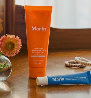 Marin Soothing Hydration Cream and blue lip treatment displayed on a wooden table.