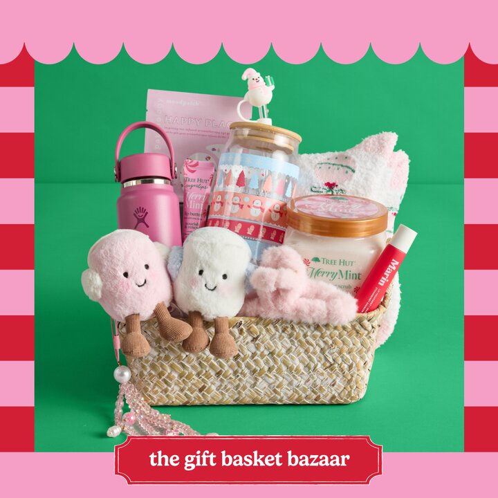 A woven gift basket with two plush stuffed animals, beauty items, a water bottle, a clear coffee cup, and other items