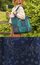 Woman outdoors carrying a teal and navy patchwork bandana-print tote bag beside a close-up of navy bandana-patterned fabric.