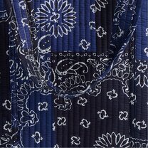 Close-up of navy quilted fabric with a white bandana-inspired print.