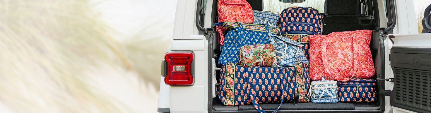Image of Vera Bradley Totes, Duffels, Backpacks and Cosmetic cases in the trunk of a Jeep. Featuring new prints Sherbet, Cambridge Blues, Vibrant Paisley, Flowering Paisley and Maison Blue