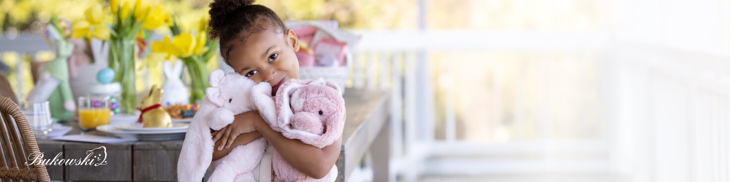 Image of a young girl hugging two Bukowski bunnies at an Easter brunch