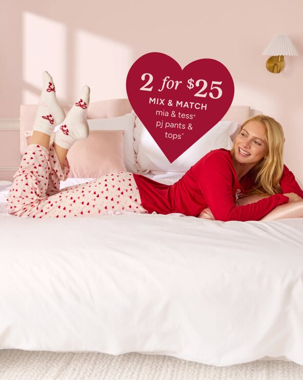 Image of a model in a pink room on a bed wearing mia & tess valentines pajamas. callout for 2 for $25 mix & match mia & tess pj pants & tops* exclusions apply