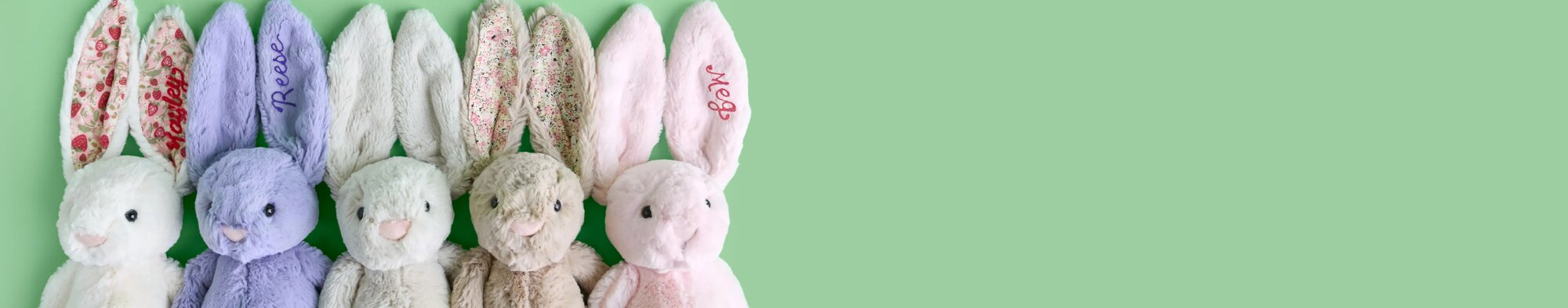 image of five jellycat bunnies in various colors. one with embroidered "Reese" on the ear and one with embroidered "Meg" on the ear