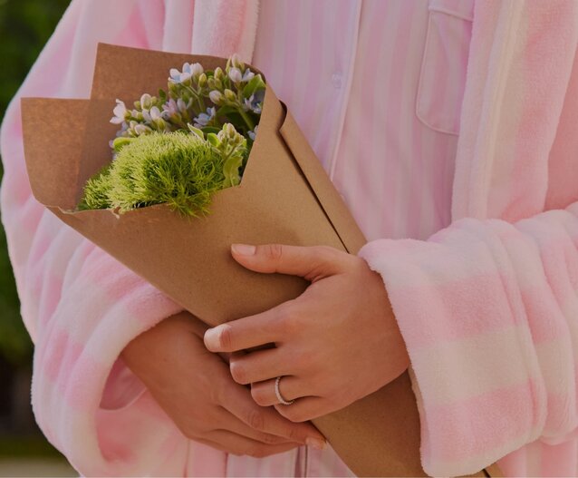 3 Pandora Images - one close up of a hand with a flower ring, one of a model wearing a charm bracelet, and one of a model wearing a necklace with pink heart charms