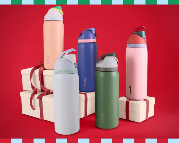 Five different colored Owala water bottles displayed in front of a red background