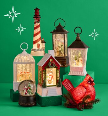Three glitter lanterns lit up in front of a green background