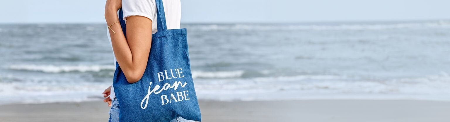  Model holding a denim tote reading "blue jean babe"