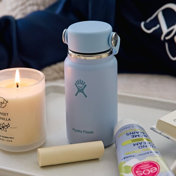 Image of a mini hydroflask on a tray with a candle, lip blam and EOS hand lotion