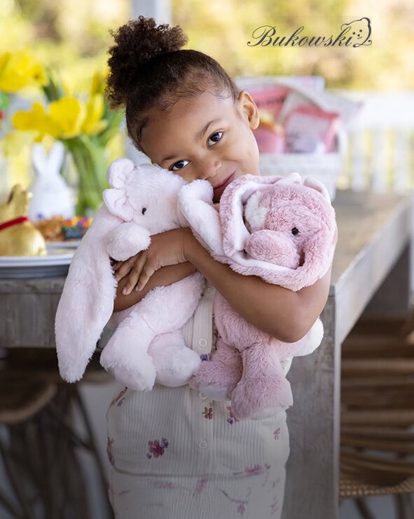 Image of a young girl hugging two Bukowski bunnies at an Easter brunch