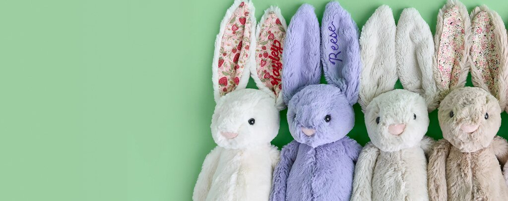 image of four jellycat bunnies in various colors. one with embroidered "Reese" on the ear