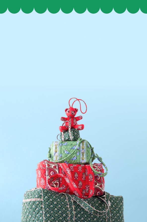 Two models wearing festive sweaters in the snow on a red background