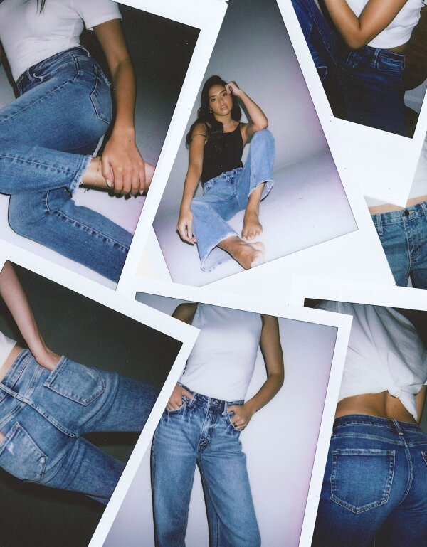 A collage of Polaroid-style photographs scattered on a light surface, all featuring denim jeans. The photos show various angles and styled shots: a person seated wearing light-wash straight-leg jeans with a black top, close-up details of denim waistbands and back pockets, a neatly folded stack of jeans and white shirts on a pedestal, and a standing figure in a white fitted top and light-wash straight jeans. The overall aesthetic is editorial and fashion-forward, with a film photography feel.