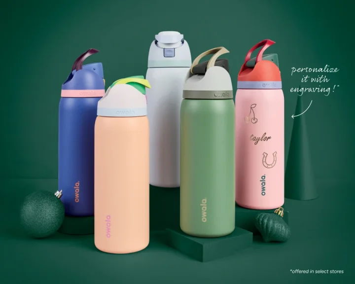Image of five different colored Owala water bottles displayed in front of a dark green background. Text on the image reads "personalize it with engraving" 