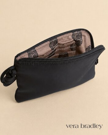 Black Vera Bradley zip wristlet with a loop handle, shown partially open to reveal a patterned interior.