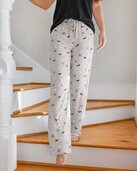 Woman wearing gray Halloween-print Mia & Tess pajama pants on a staircase - Buy 1, Get 1 50% off