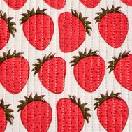 Close up of a vertically quilted white fabric with a bright red strawberry print