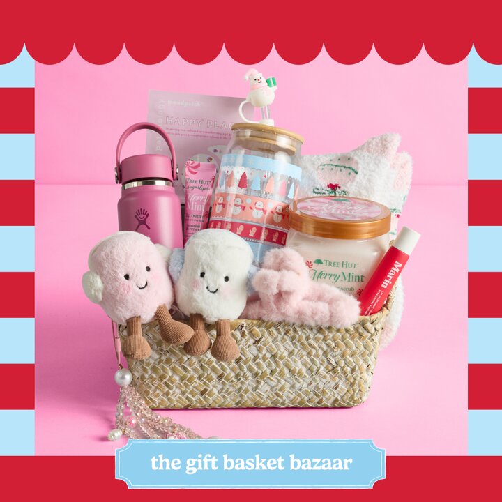 A woven gift basket with two plush stuffed animals, beauty items, a water bottle, a clear coffee cup, and other items