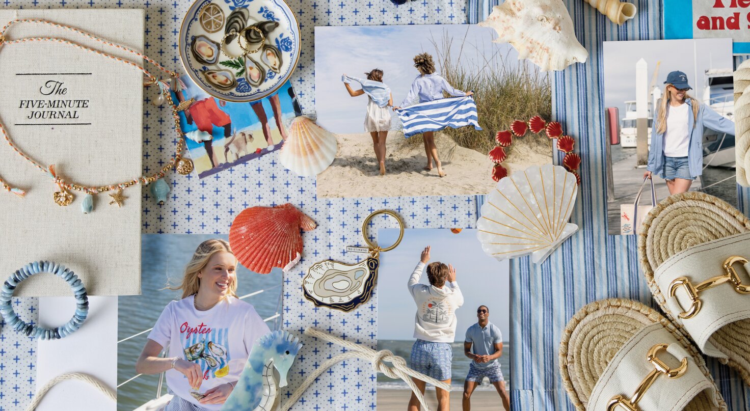 Flat lay collage with a coastal beach theme, featuring printed photos of friends by the ocean, seashells, a red scallop shell, oyster-pattern jewelry, a rope keychain, striped fabric, woven sandals with gold buckles, a straw bag, a blue beaded bracelet, and a beige journal titled “The Five-Minute Journal” arranged on a blue-and-white patterned background.