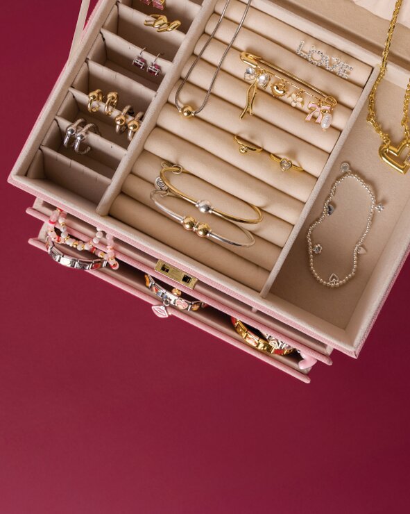 image of an open jewelry box on a maroon backgroung. features Cape Cod Jewelry, Italian charm bracelets and Kendra Scott.